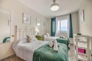 A hotel room with two beds, a nightstand, a dresser, a window with curtains, and artwork on the walls. - LXR Jazmines 2-Bedroom, Downtown (Fuengirola)