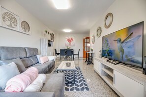 A modern living room with a grey sofa, a coffee table, and a flat-screen TV. - LXR Jazmines 2-Bedroom, Downtown (Fuengirola)