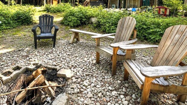 Uma cabana com varanda, área de estar externa e lareira.