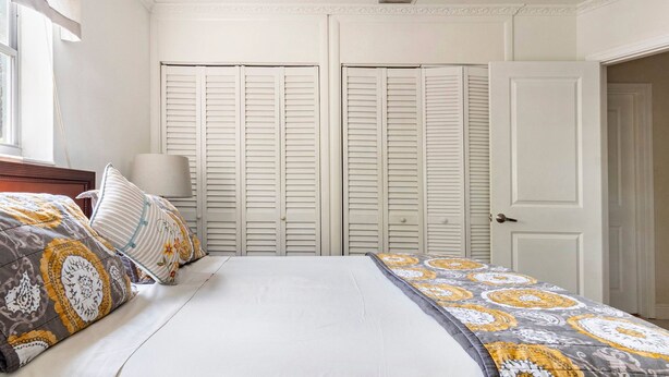 A bedroom with a bed, two wardrobes, a nightstand, and a lamp. - 3BR Home Near Fort Lauderdale Beach | Sleeps 5 (Fort Lauderdale)