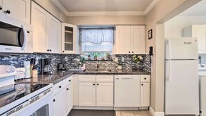 A modern kitchen with white cabinets, a microwave, a stove, a sink, and a refrigerator. - 3BR Home Near Fort Lauderdale Beach | Sleeps 5 (Fort Lauderdale)