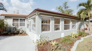 A single-story house with a covered porch, white exterior walls, and a number '101' on the side. - 3BR Home Near Fort Lauderdale Beach | Sleeps 5 (Fort Lauderdale)