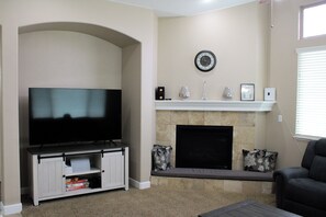 A living room with a television, fireplace, and seating area. - Madrone Manor, A Beautiful Spacious Getaway (Elverta)