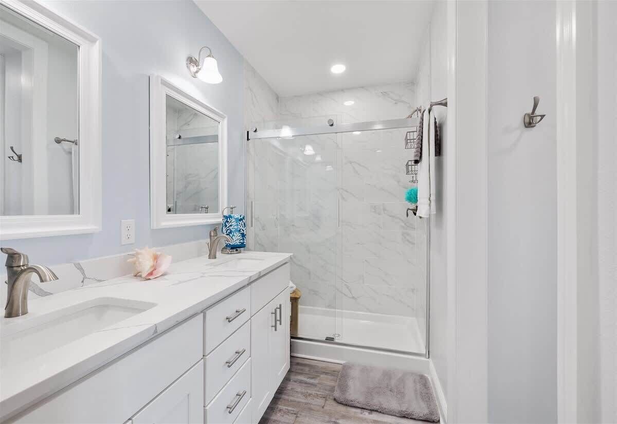 A bathroom with a shower, a sink, and a mirror.