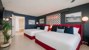 A hotel room with two beds, a checkered wall, and a 'START YOUR ENGINES' sign.