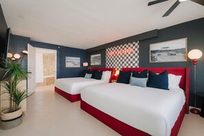 A hotel room with two beds, a checkered wall, and a 'START YOUR ENGINES' sign.