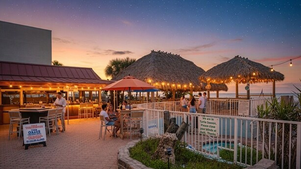 An outdoor dining area with tables and chairs, a pool, and thatched umbrellas.