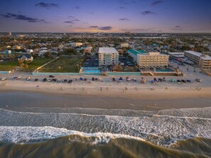 A beachfront hotel with multiple buildings, a sandy beach, and waves. - Top-Floor Oceanfront Suite • Sleeps 6 (Daytona Beach)