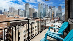 Ein Balkon mit Blick auf die Stadt, darunter Hochhäuser und Baukräne.