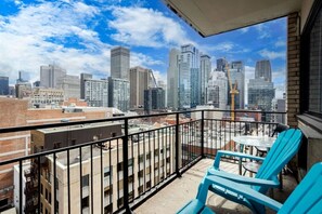 Ein Balkon mit Blick auf die Stadt, darunter Hochhäuser und Baukräne.