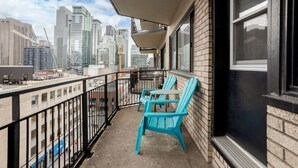 Un balcon avec vue sur la ville, une table et deux chaises.