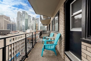 A balcony with a city view, a table, and two chairs. - Upscale Apartment in Montréal (Montreal)