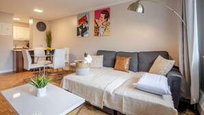 Un salon moderne comprenant un canapé, une table basse et un coin repas avec des chaises et une table.