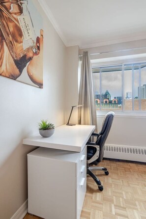A modern office space with a desk, chair, and a potted plant. - Upscale Apartment in Montréal (Montreal)