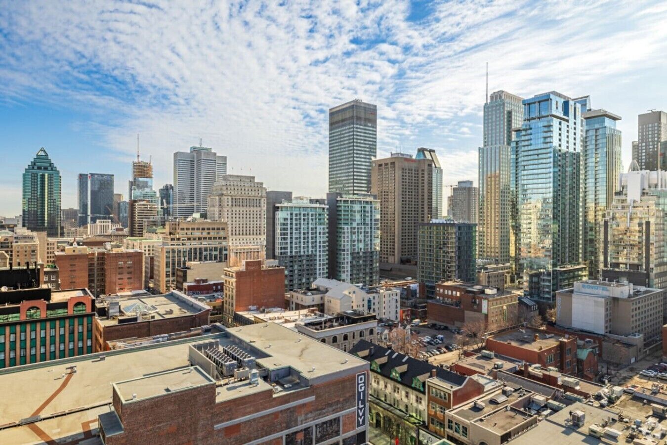 Un paysage urbain caractérisé par une diversité de hauteurs de bâtiments, comprenant des gratte-ciel modernes et des constructions plus anciennes.