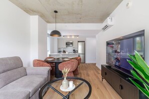A modern living room with a sofa, a coffee table, and a TV. - The Velvet Loft Montréal (Montreal)