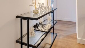 A hallway with a black console table, a framed picture, and a 'Home' sign. - CityGlow Montréal w/ Free Parking (Montreal)