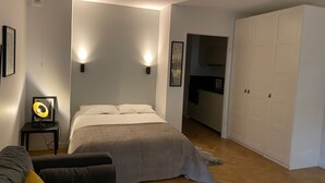 Une chambre à coucher avec un lit, des lampes de chevet, une armoire et une petite table avec une lampe.