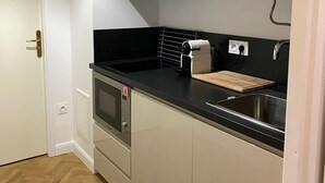 Une cuisine compacte dotée d’un four encastré, d’un évier et d’un plan de travail.