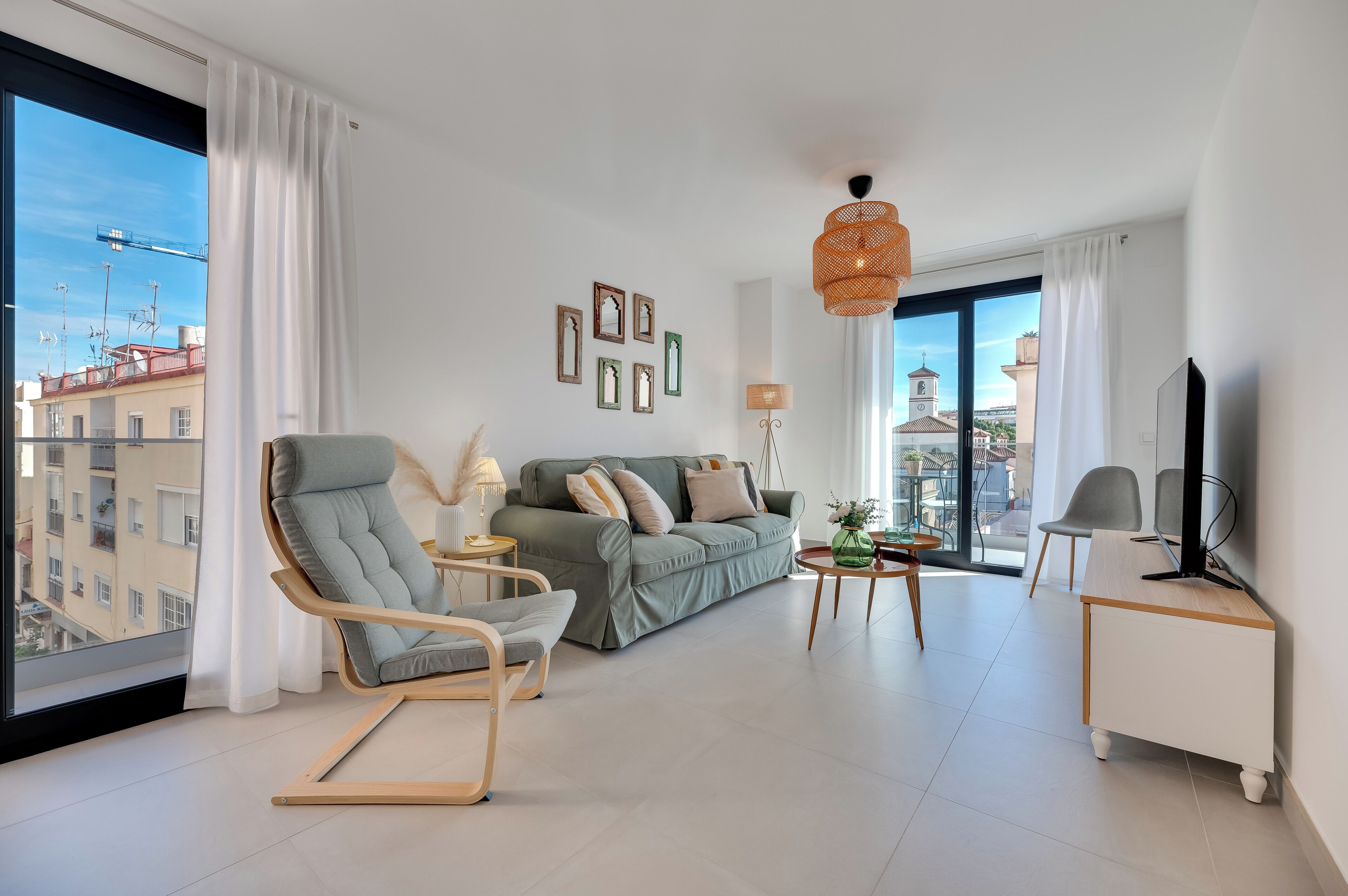 Un salon moderne comprenant un canapé, un fauteuil à bascule, une table basse et un meuble pour la télévision.