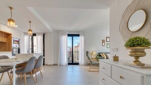 En moderne stue med spiseområde, et køkken og en balkon med udsigt.