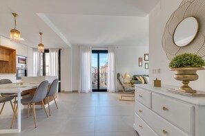 A modern living room with a dining area, a kitchen, and a balcony with a view. - LXR Indico 2-Bedroom Apartment by the Sea (Fuengirola)