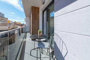 A balcony with a glass railing, a round table, and two chairs. - LXR Indico 2-Bedroom Apartment by the Sea (Fuengirola)