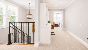 A spacious room with a staircase, a bed, a chair, and a desk. - The Retreat, 3BR Wlk-SQ+grill by Velvet Ditch Villas (Oxford)