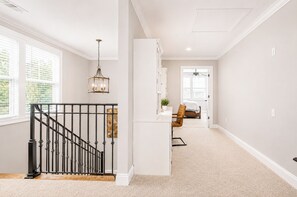 A spacious room with a staircase, a bed, a chair, and a desk. - The Retreat, 3BR Wlk-SQ+grill by Velvet Ditch Villas (Oxford)
