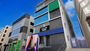 Een hotel met meerdere verdiepingen, een moderne gevel, grote ramen en een duidelijke trap naar de ingang.