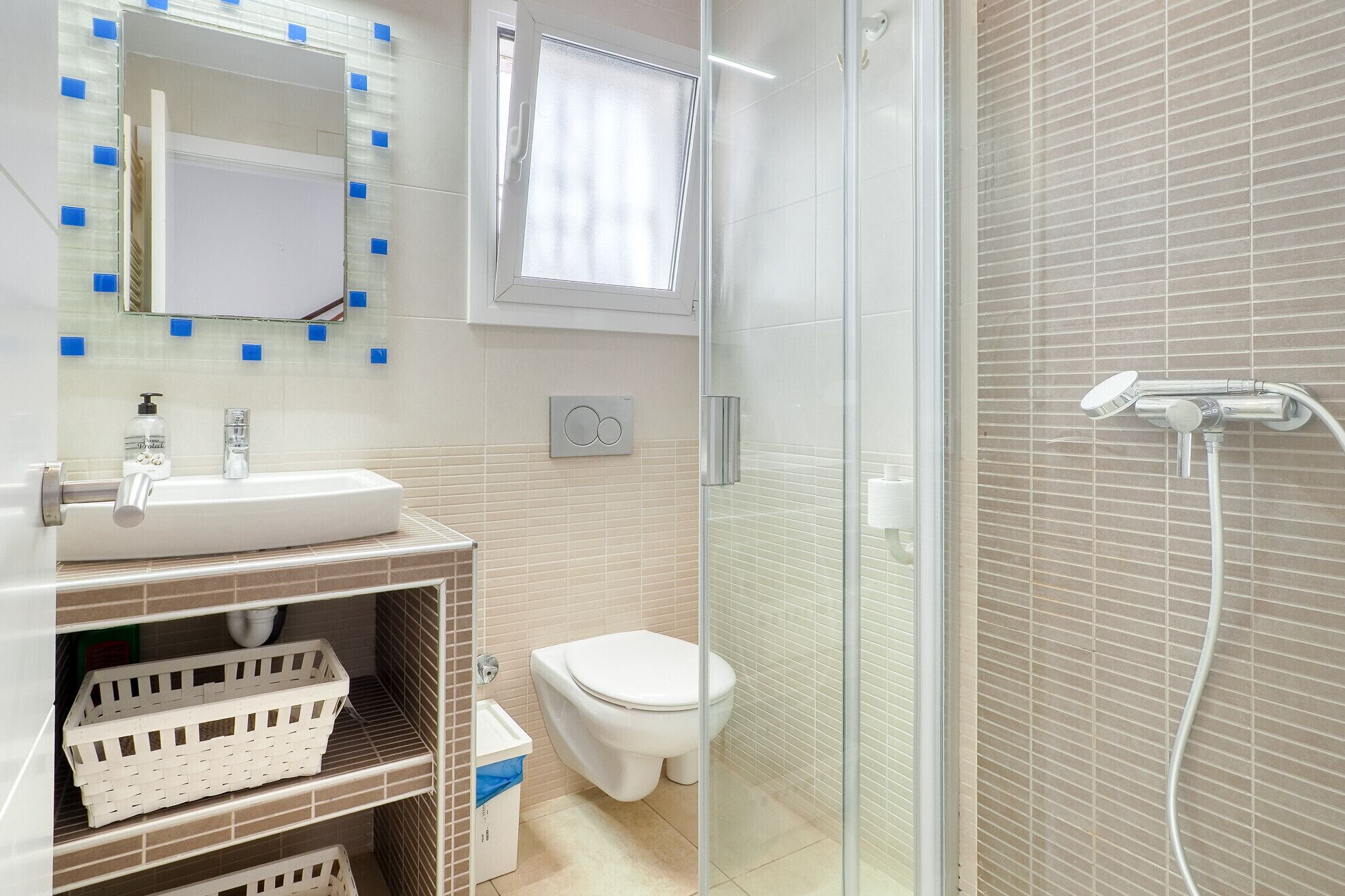 A bathroom with a sink, toilet, and shower.