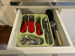 A drawer with compartments containing various kitchen utensils. - Residencial Tristão de Oliveira (Gramado)