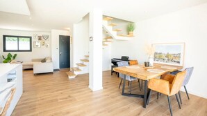 A modern interior with a dining area, a staircase, and a living room. - Beautiful Montpellier Villa With Pool (Montpellier)