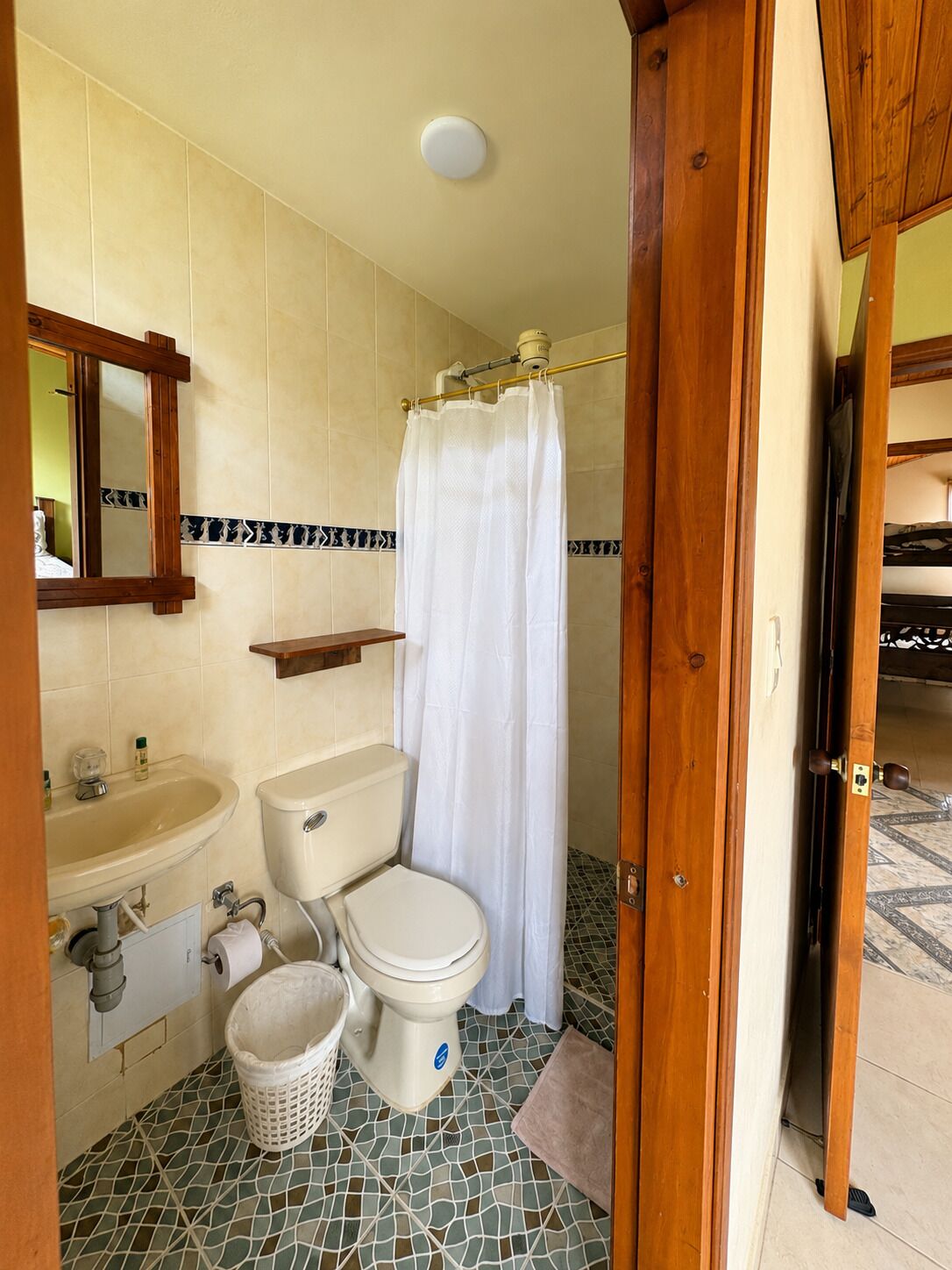 Une salle de bain avec des toilettes, un lavabo et un rideau de douche.