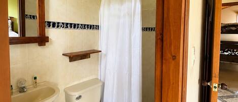 Une salle de bain avec des toilettes, un lavabo et un rideau de douche.