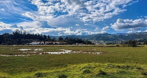 A rural landscape with a clear sky, a small settlement with houses, and a mountain range in the background. - Casa Hotel Descanso Real (Paipa)