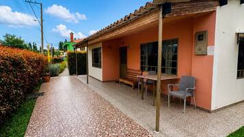 A residential building with a tiled patio, a chimney, and a clear blue sky.