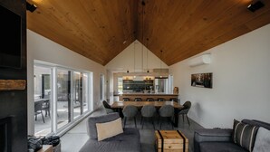 Et moderne interiør med spiseplads, sofaer og et køkken.