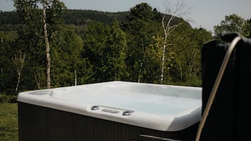Un jacuzzi con vistas a una ladera boscosa.
