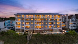 Ein mehrstöckiges Hotel mit Balkonen, einem Schwimmbad und Blick auf den Strand.