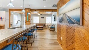 Une cuisine moderne avec un coin bar, un plancher en bois et un grand tableau accroché au mur.