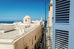 Vista d'un edifici amb cúpula i un balcó que s'obre a un carrer i al mar.