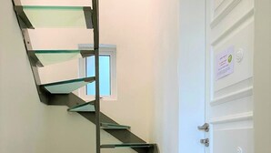 En spiraltrappa med glassteg som leder upp till en liten plattform.