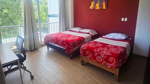 A hotel room with two beds, a desk, and a balcony with a view. - The perfect home for vacations, weekend getaways, family gatherings, and pets (Ixtapan De La Sal)