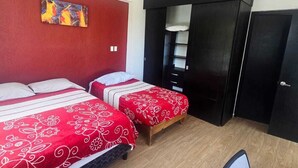 A room with two beds, a desk, a chair, a wardrobe, and a painting on the wall. - The perfect home for vacations, weekend getaways, family gatherings, and pets (Ixtapan De La Sal)