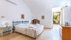 A bedroom with a bed, bedside table, lamp, dresser, and a view of the outdoors. - Ottava Dimora Del Pizzo - Gallipoli (Gallipoli)