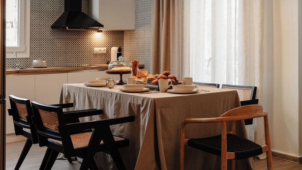 A dining area with a table set for four, featuring a variety of pastries and a coffee station. - Naxian Nest suites & houses (Naxos)