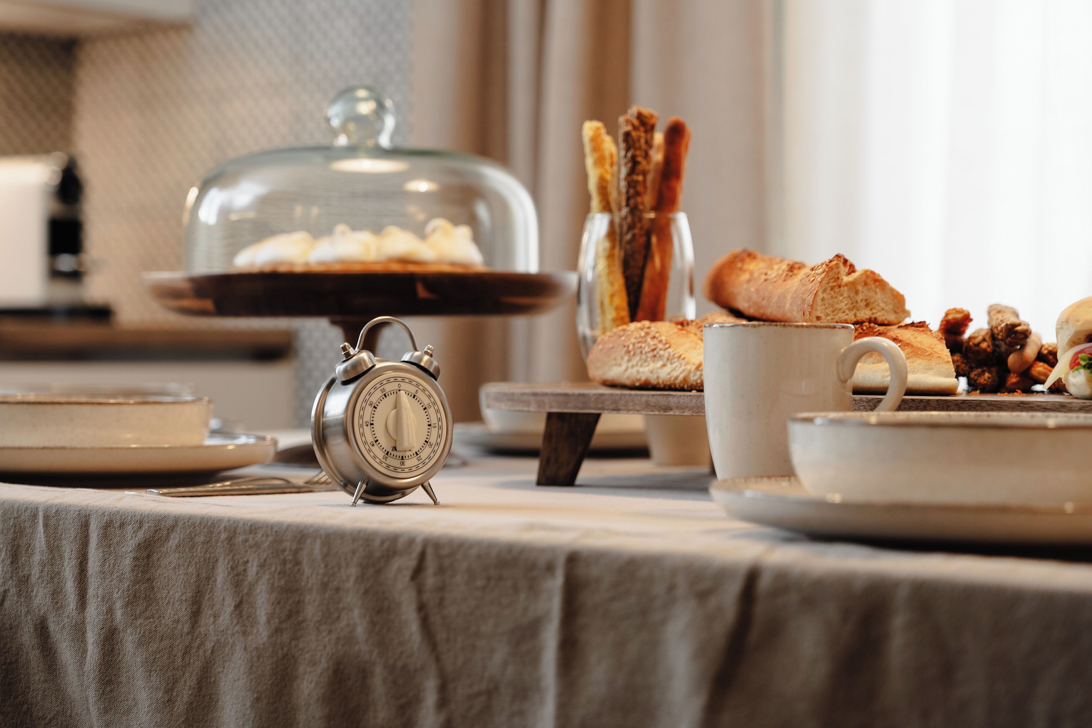 A breakfast buffet with a variety of pastries, bread, and a coffee cup on a table.