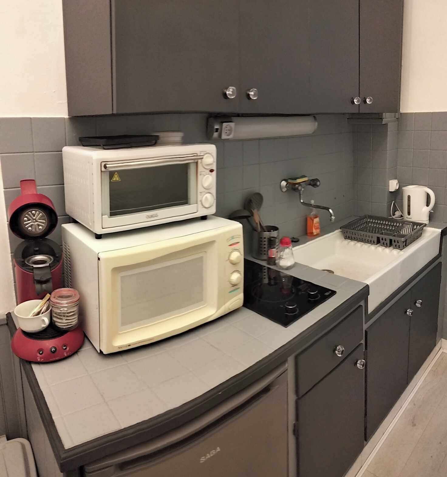A kitchen with a microwave, stove, sink, and cabinets.