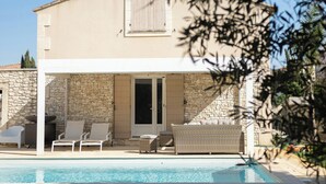 A two-story house with a swimming pool, outdoor seating, and a stone wall. - Family domaine with pool in the Camargue region (Arles)